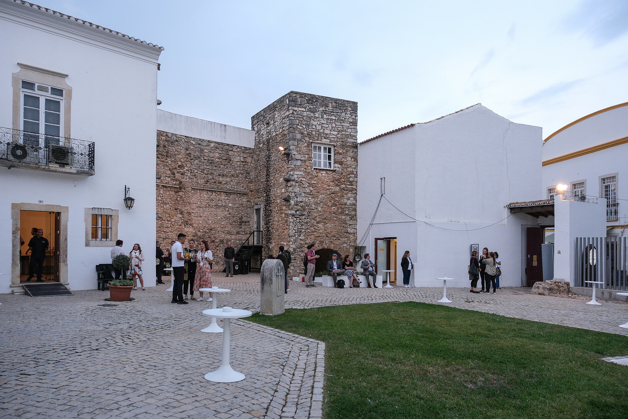 People are standing in groups inside a historic courtyard.  © Image: Jorge Gomes