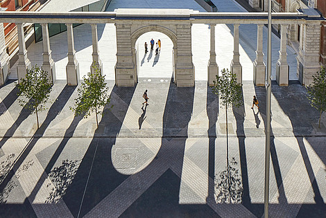 This photograph is taken from bird perspective and depicts a court yard. The pillars of the opposite building cast long shadows.  © Hufton + Crow, Victoria and Albert Museum