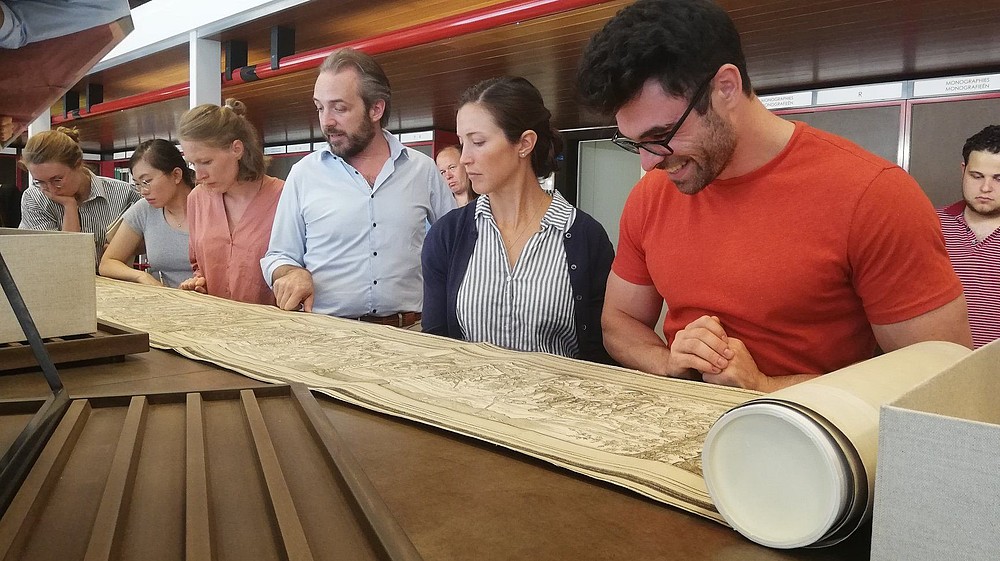 Five people reading an ancient text that is rolled out in front of them.  © Flemish Art Collection-SummerCourse 2019