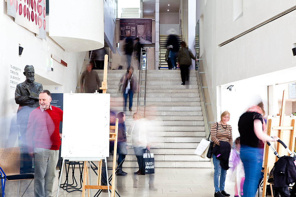 Several people moving in a staircase during a painting workshop at a museum. They are blurry due to the long exposure of the photograph.  © National Gallery of Ireland