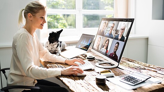 A person sits in front of their desk having a video conference.