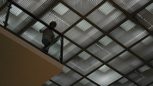 Child looks down through glass floor tiles. 