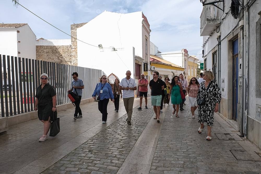 A group of people is walking through the streets with a tour guide.  © Image: Jorge Gomes