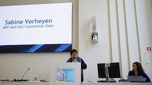 Member of European Parliament Sabine Verheyen stands behind a podium and speaks into a hand-held microphone.  © Image: Peter Vand der Plaetsen