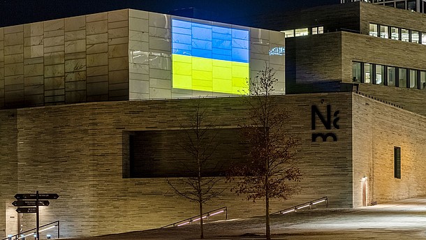  The Ukrainian flag is projected on the wall of a modern building.