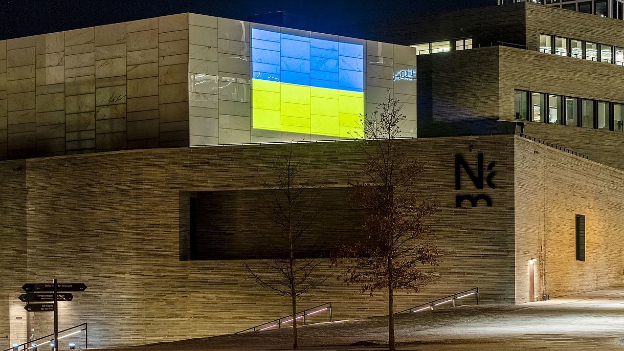  The Ukrainian flag is projected on the wall of a modern building.
