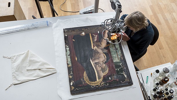  Bird perspective of someone doing restoration work on an icon painting. 
