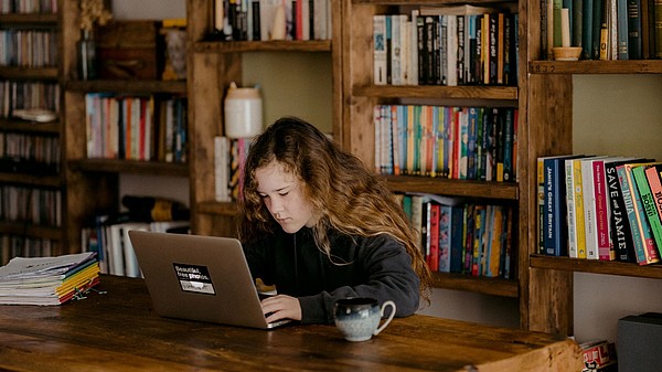 Young person writing on a laptop