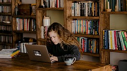 Young person writing on a laptop