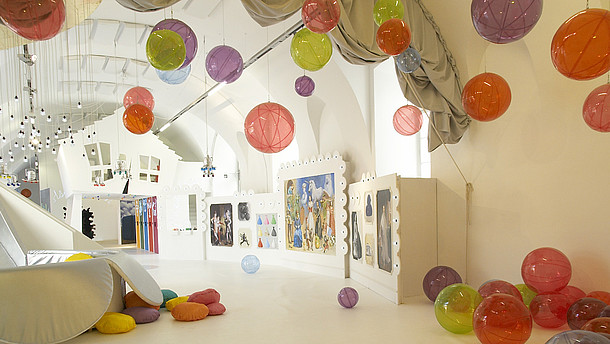  Empty spacious and white room filled with plastic see-through balls. The balls are scattered around the room on the floor, on the walls and attached to the ceiling. 
