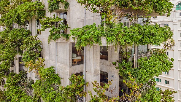  A modern concrete building is covered by a vertical garden.