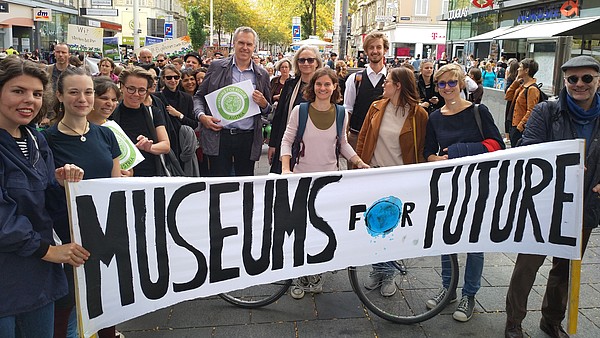 Group of people at a demonstration for the environment carrying a banner that says "Museums for Future"