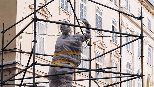 Statue wrapped in protective material.