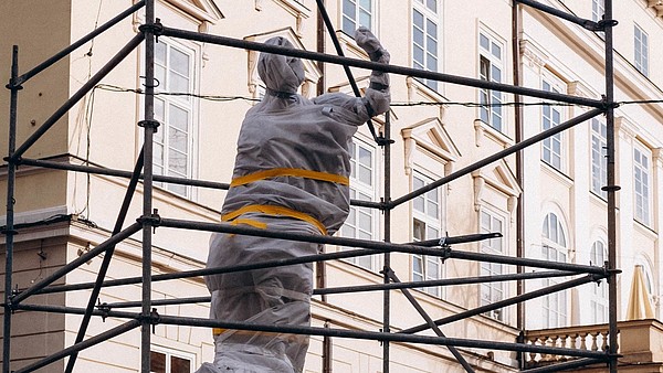 Statue wrapped in protective material.