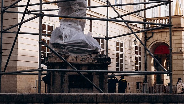 Statue wrapped in protective material.