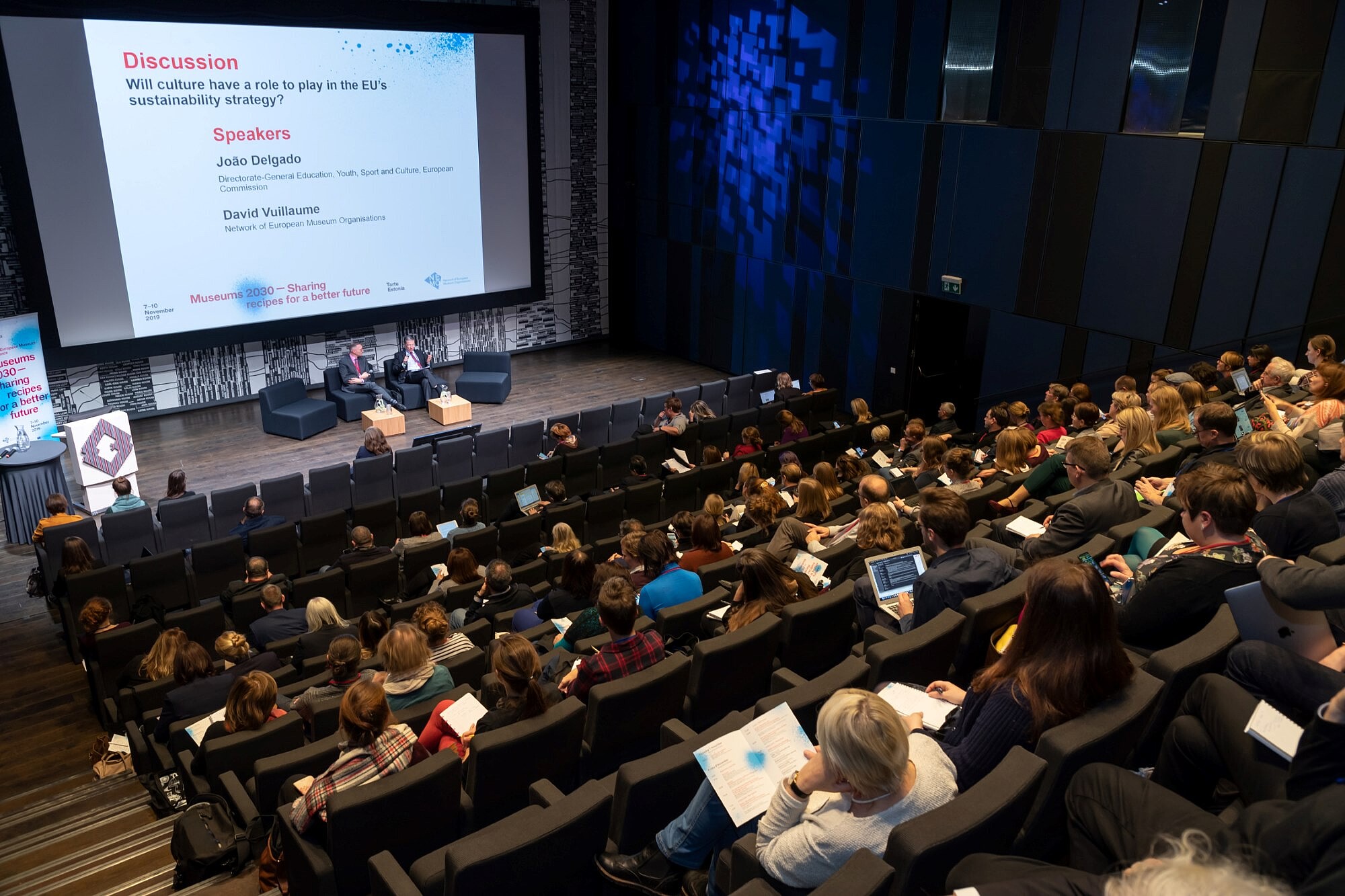 © Image: Arp Karm Auditorium full of people looking at two people on the stage. A sign shows that they are discussing EU culture policy. © Image: Arp Karm