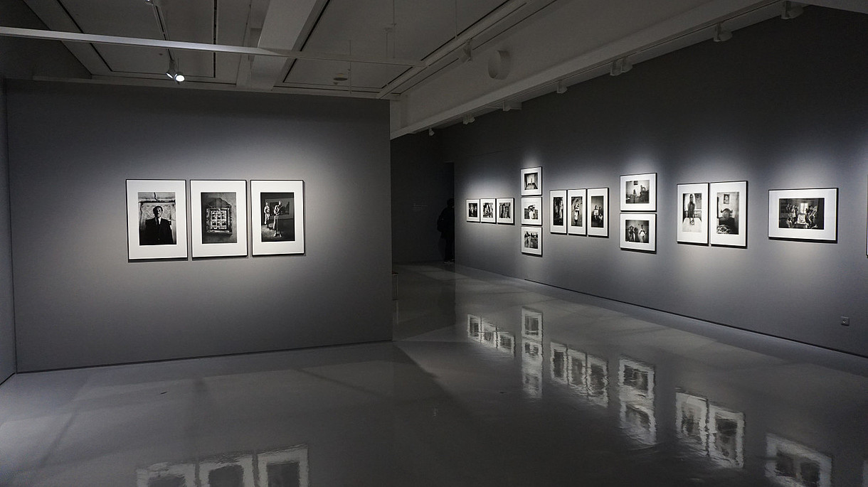 © Image: Eric Park Grey gallery space with shiny floors that reflects the photos hung on the walls.