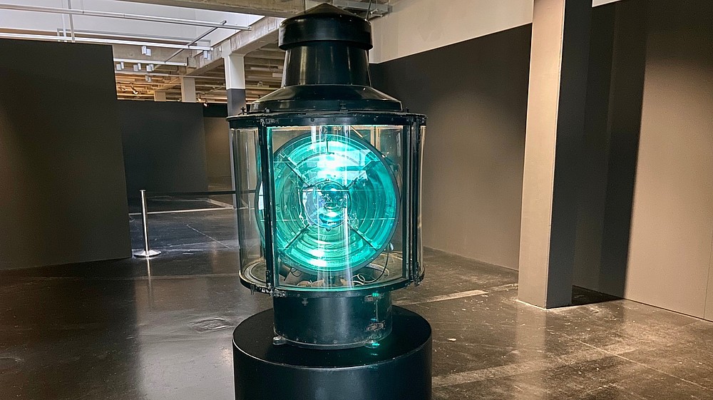 A big electric lantern stands inside an empty exhibition space.  