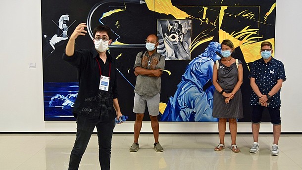 A man is taking a selfie of himself and three other people standing behind him in front of a big painting. They are all wearing face masks.   © Arxiu Fotogràfic del Consorci del Patrimoni de Sitges  
