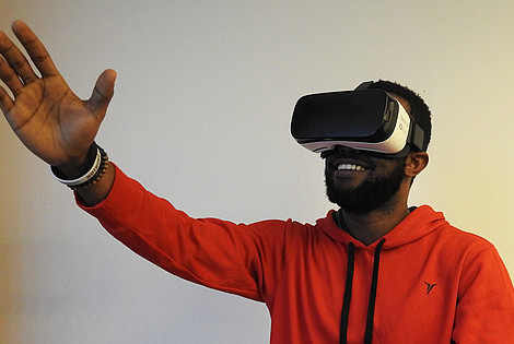 Man in an orange hoodie is using a pair of virtual reality glasses  © Image: Hammer Tusk
