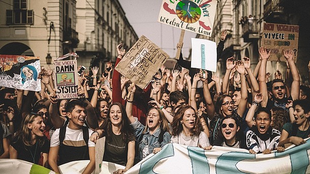  Young people are shouting and holding banners during a climate protest.